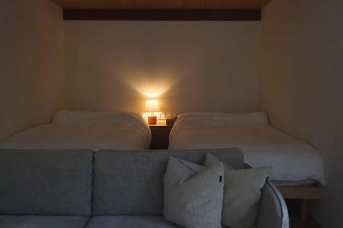 a living room with two beds and a couch at The Cabin by Deep Gorge in Kita-karuizawa