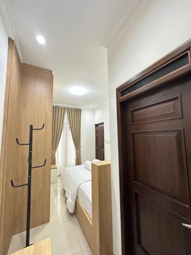a bedroom with a bed and a wooden door at Moses Homestay, Yogyakarta in Beran-kidul