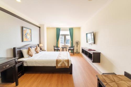 a large bedroom with a bed and a table at Royal Dalat Hotel in Da Lat