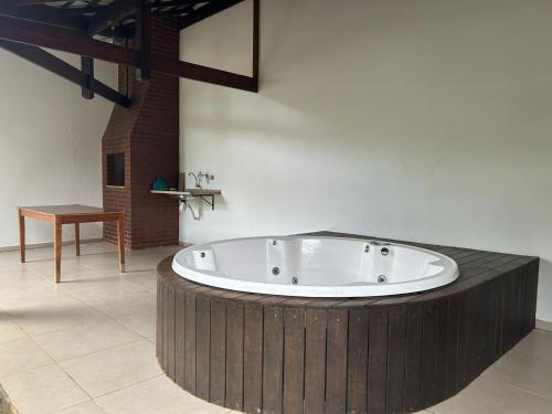 a large bath tub in a room with a table at Quintal da Serra in Morretes