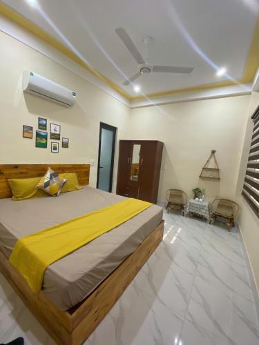 a bedroom with a large bed and two chairs at Nhật Lệ Oyster House in Dong Hoi