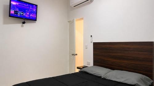 a bedroom with a bed and a flat screen tv at Lumina loft express minutes to consulate in Hermosillo