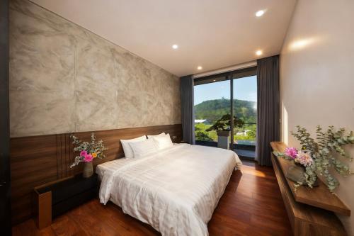 a bedroom with a large bed and a large window at La Lapine Villa -6rooms-15Pax in Khu Chi Lăng
