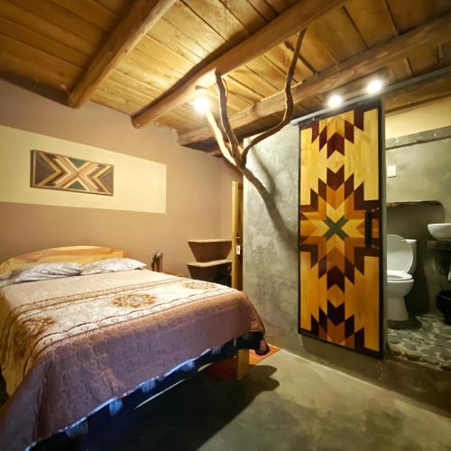 a bedroom with a bed and a painting on the wall at Yanamanka in Yanama