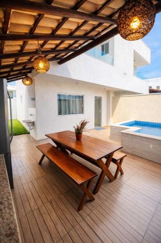 a wooden table and a bench on a patio at Bahia Bela - Casa Duplex 02 in Santa Cruz Cabrália
