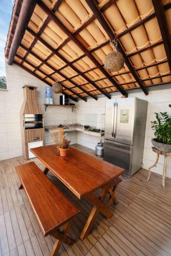 a kitchen with a wooden table and a refrigerator at Bahia Bela - Casa Duplex 02 in Santa Cruz Cabrália