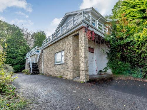 a brick building with a balcony on top of it at Five Bays View in Aberporth
