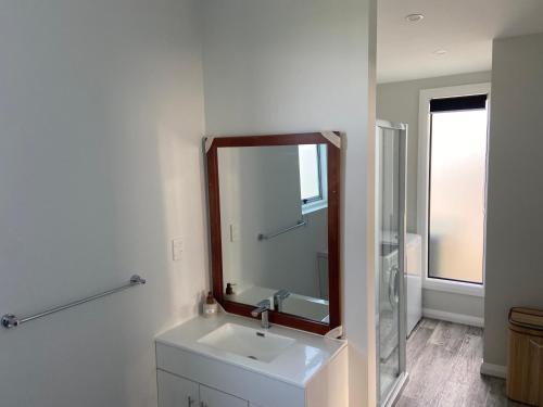 a bathroom with a sink and a mirror at The Jam Shed in Waimate