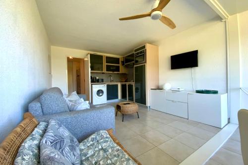 a living room with a couch and a ceiling fan at Le Studio de la Lagune studio cabine proche de la plage in Le Grau-du-Roi