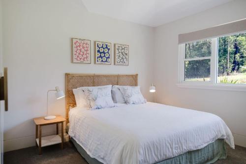 a white bedroom with a bed and a window at Lakeside House - Waterfront, Spacious, Pool Table in Yatte Yattah
