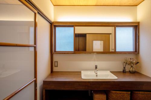 a bathroom with a sink and a mirror at goemon-inn in Akita