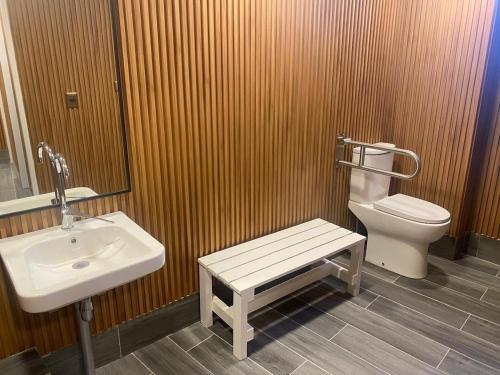 a bathroom with a sink and a toilet and a bench at Algarrobo, Pinares de Canelillo in Algarrobo