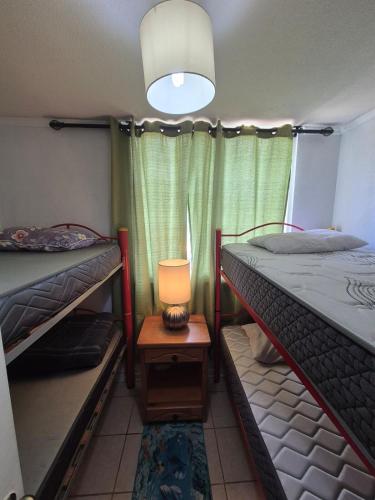 a room with two bunk beds and a lamp on a table at Algarrobo, Pinares de Canelillo in Algarrobo