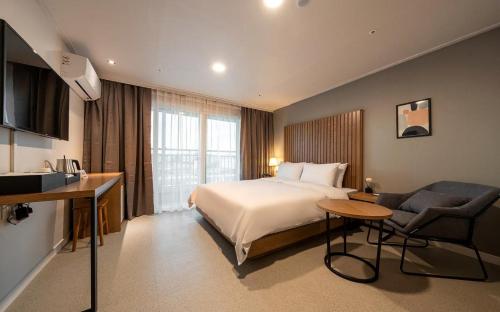 a hotel room with a bed and a couch at Hotel Corner Inn in Pyeongtaek