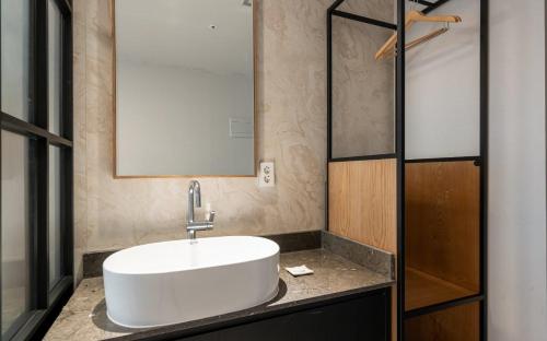 a bathroom with a white sink and a mirror at Hotel Corner Inn in Pyeongtaek