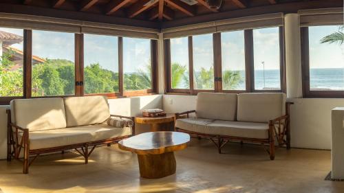 a living room with two chairs and a table at Refugio de piedra - Troncones in Troncones