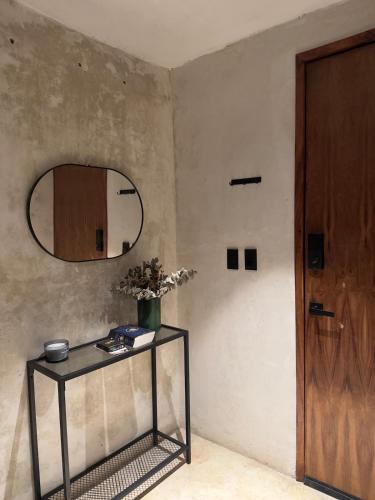 a room with a table and a mirror and a door at Bello departamento centrico in Valladolid