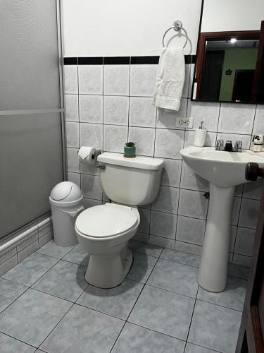 a bathroom with a toilet and a sink at Amplio y cómodo departamento. in Loja