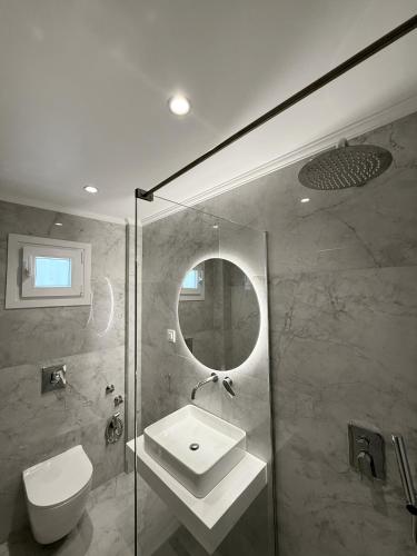 a bathroom with a sink and a toilet and a shower at Captains Studios & Apartments in Kavos