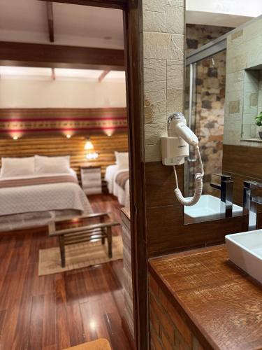a bedroom with a bed and a phone on the wall at Hotel de Sal Atipax in Uyuni