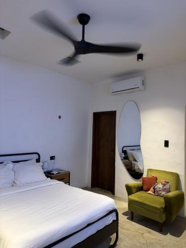 a bedroom with a bed and a fan and a chair at Departamento completo casarosa in Valladolid