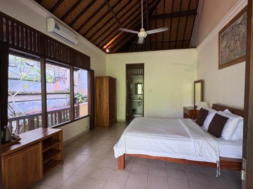 a bedroom with a bed and a ceiling at Raka Rai Bungalows in Ubud