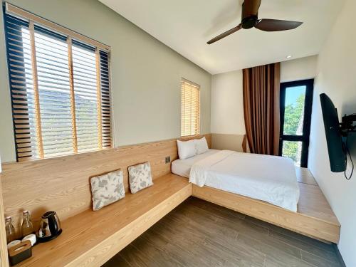 a bedroom with a bed and a large window at Soleil Crown Boutique in Thôn Trường Giang