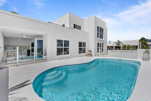 a swimming pool in front of a house at WhitsunStays - The Cyclades in Eimeo