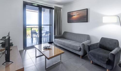 a living room with a couch and a chair and a table at WhitsunStays - The Regal (2br/2bth, Central) in Mackay