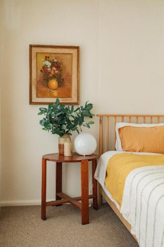a bedroom with a bed and a table with a plant on it at Georgie Bay St Helens in St Helens