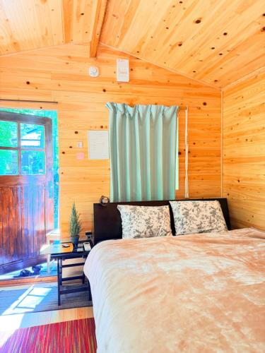 a bedroom with a bed in a wooden room at Foresta Karuizawa 6 "Glamping & Tent" for 8 people in Karuizawa