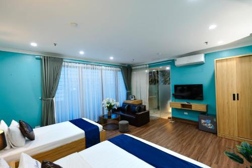 a hotel room with two beds and a television at Dream Hotel Hà Nội in Hanoi