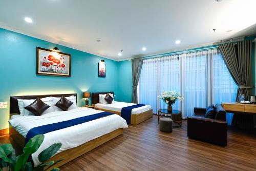 a bedroom with two beds and a blue wall at Dream Hotel Hà Nội in Hanoi