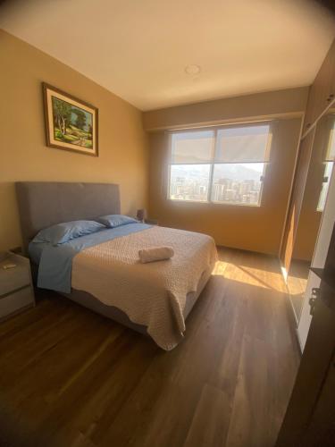 a bedroom with a bed and a large window at Apartamento céntrico y lujoso in Cochabamba