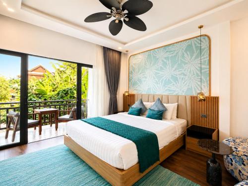 a bedroom with a bed and a balcony at Dawn Garden Luangprabang Hotel in Luang Prabang