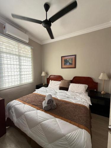 a bedroom with a large bed with a ceiling fan at Lanisa Staycation Mesra in Kampong Padang Bungor