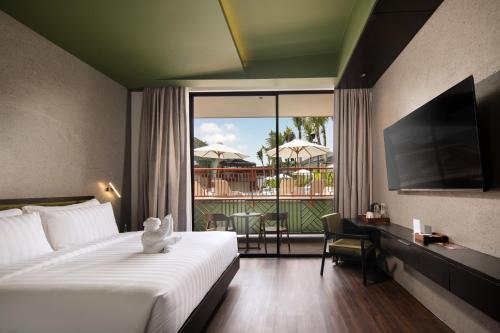 a hotel room with a bed and a view of a balcony at Maha Resort Bali in Canggu