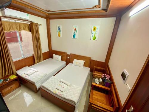 a small room with two beds and a window at Khách sạn Tam Sơn in Ha Giang
