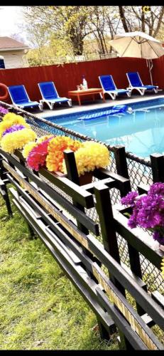 a bench with flowers on it next to a swimming pool at Luxury KIA Room E in Richmond Hill