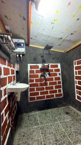 a bathroom with a brick wall and a sink at Tetebatu Cabin Hut in Tetebatu
