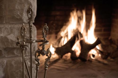 a fireplace with two candlesticks in front of a fire at La Casona del Tormes in Almenara de Tormes