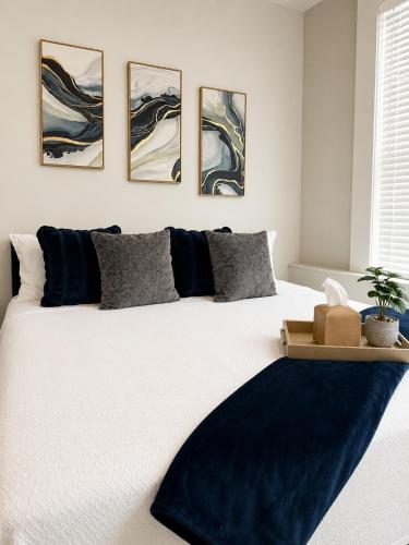 a bedroom with a large bed with four paintings on the wall at Sapphire Loft Midtown in Atlanta