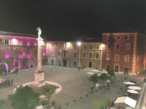 a large statue in the middle of a city at night at Ostello Palazzo Nizza in Massa