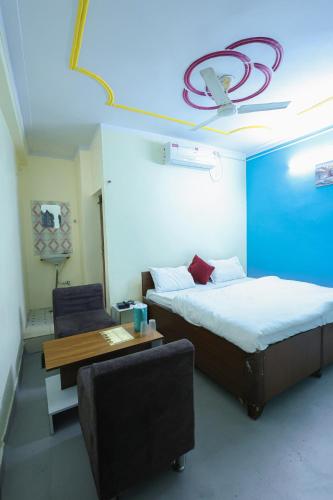a room with two beds and a table and a chair at Green Valley Hotel - Srinagar in Srīnagar