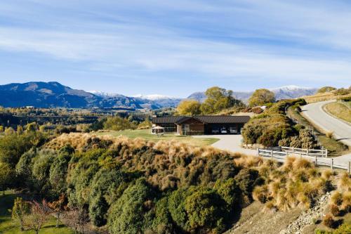 an aerial view of a house on a hill with a road at Tucker Beach Private Exclusive Retreat in Queenstown