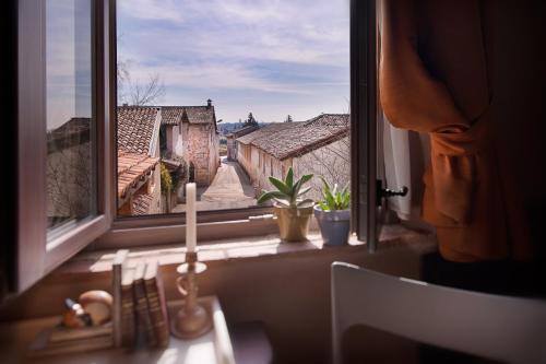 une bougie assise sur un rebord de fenêtre avec vue dans l'établissement Boutique Hotel Villa dei Campi, à Gavardo
