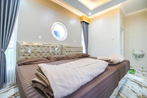 a large bed in a room with a window at M Villa in Jetis