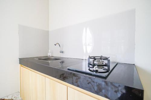 a kitchen with a black counter top and a sink at M Villa in Jetis