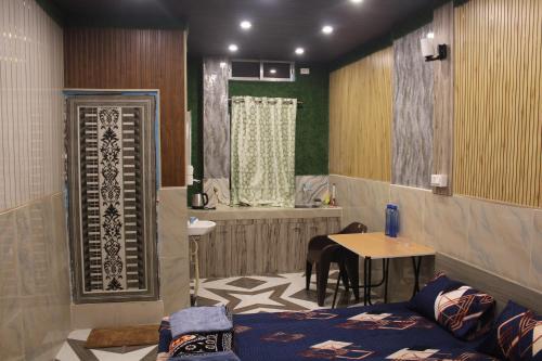 a room with a bathroom with a table and a tub at Dipankar House in Tezpur