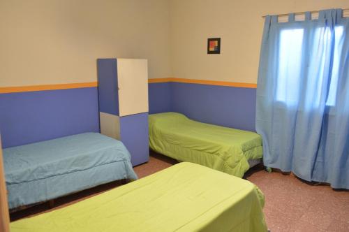 a room with two beds and blue and green at La Covacha Youth Hostel in Salta